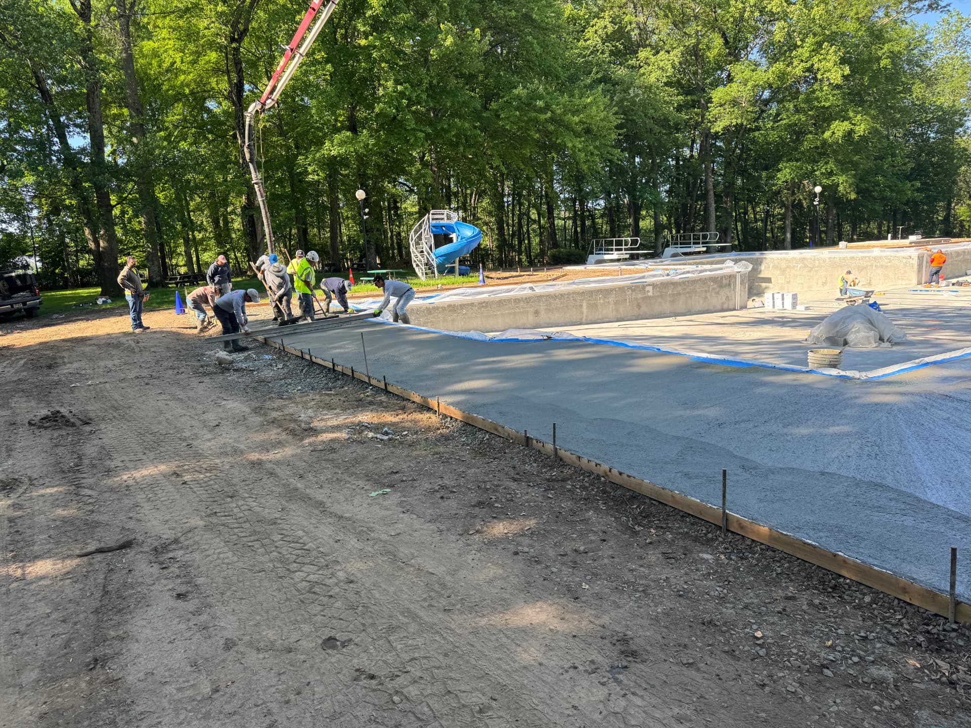 Crew placing a large concrete pool deck slab