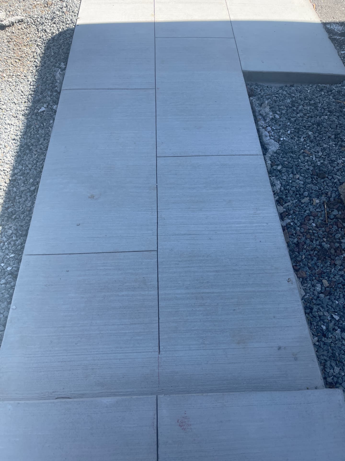 Broom finish concrete walkway with stone borders