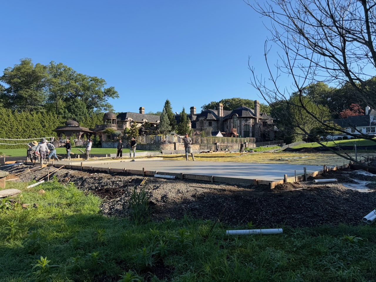 Crew placing and finishing a large concrete slab pour