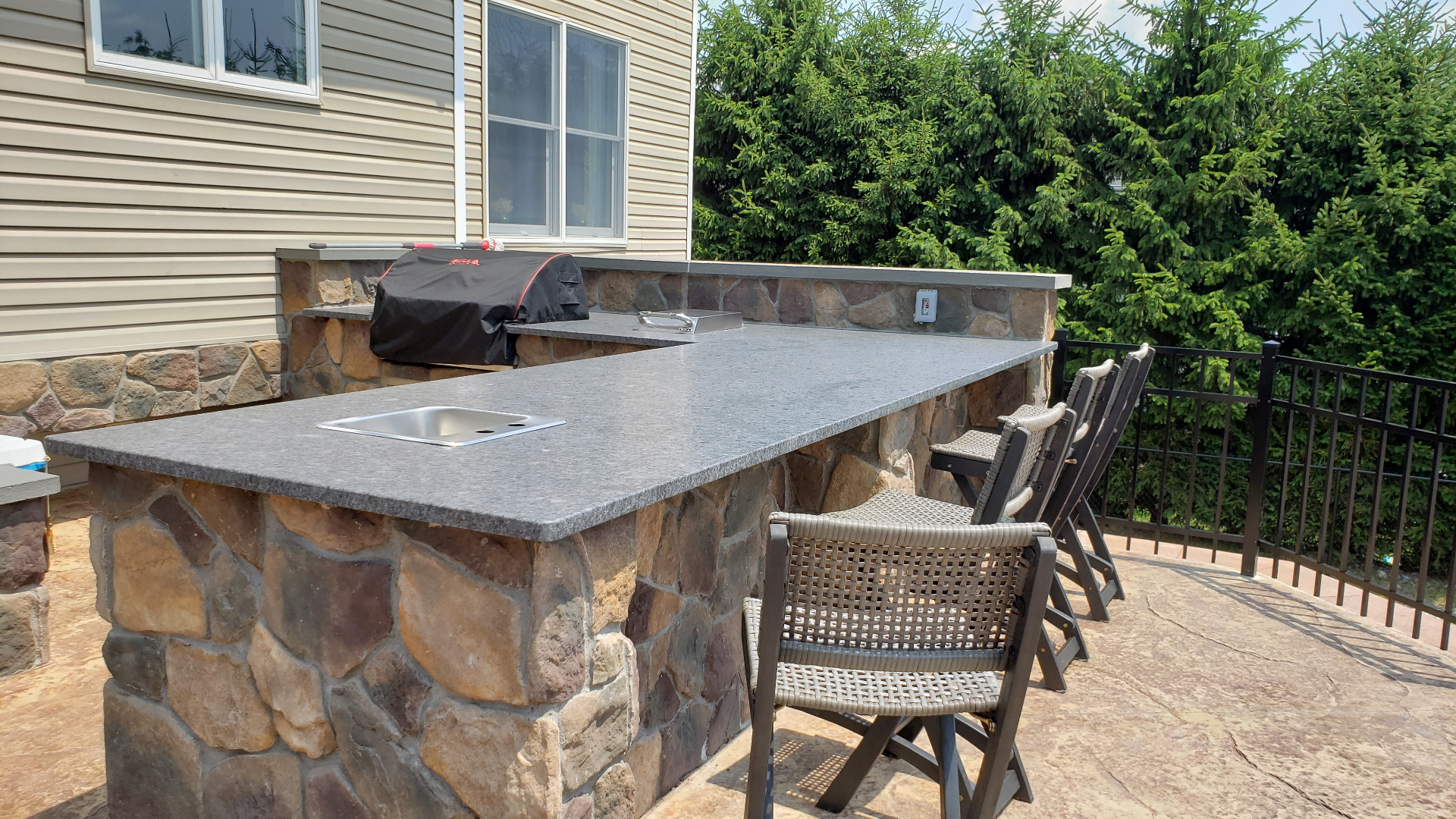 Outdoor kitchen with stone base and granite countertop