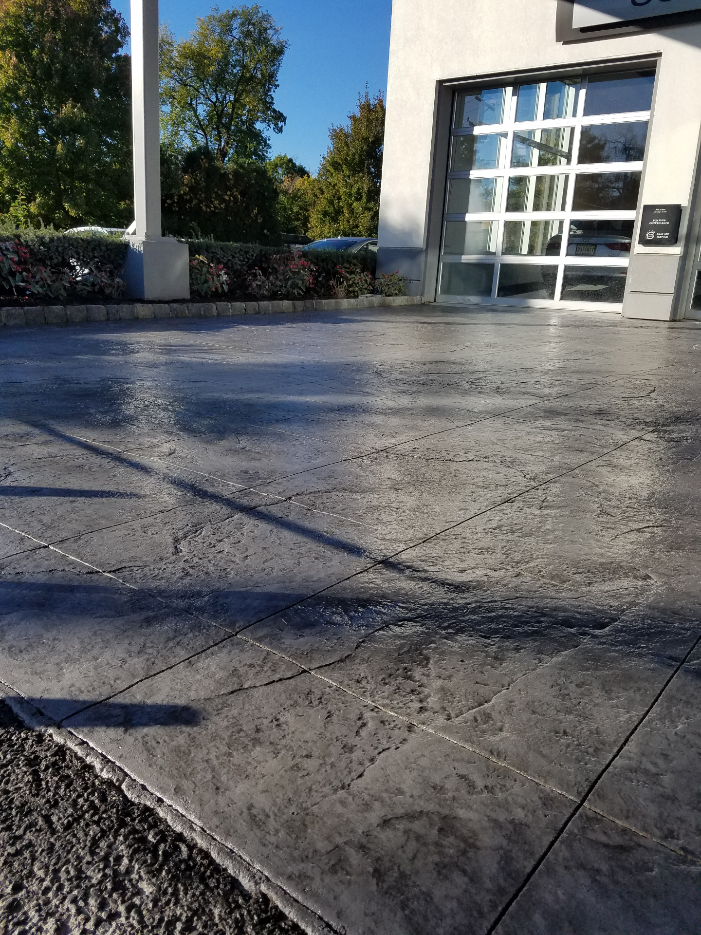 Charcoal stamped concrete entryway at auto dealership