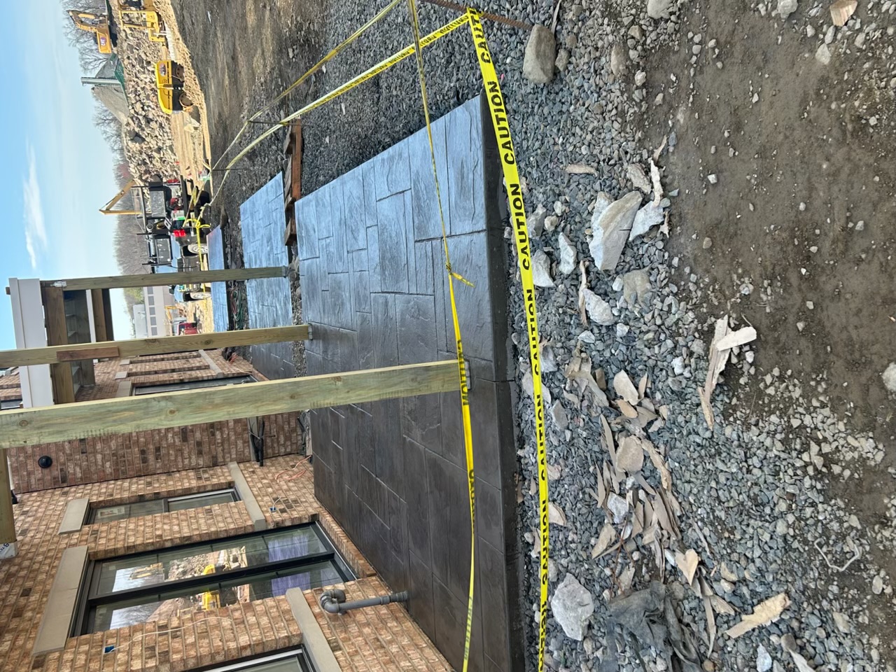Charcoal ashlar slate stamped concrete patio along a brick building