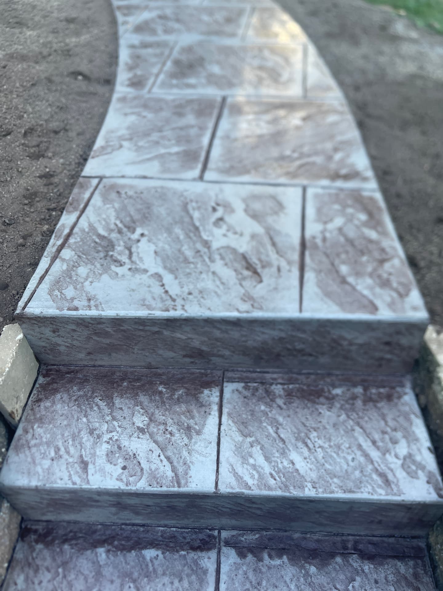 Stamped concrete steps leading to a curved walkway