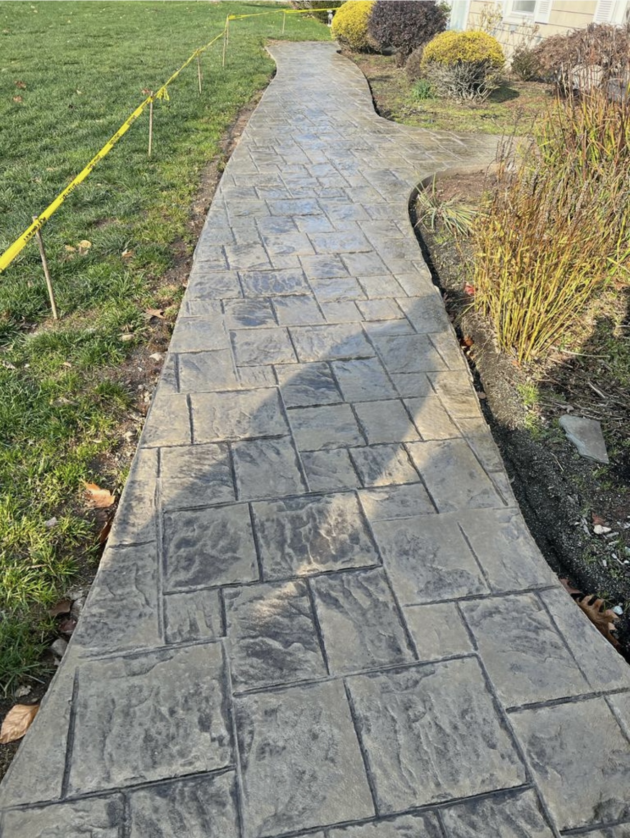 Curved ashlar stamped concrete front walkway