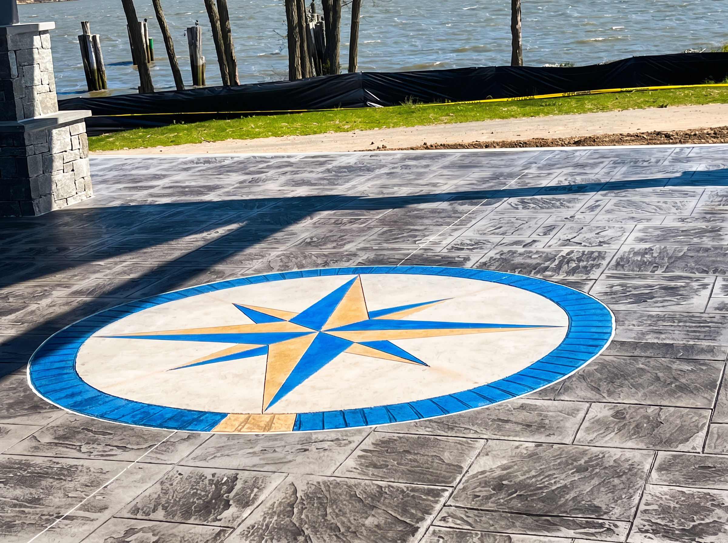 Blue and tan compass rose inlay in stamped concrete patio